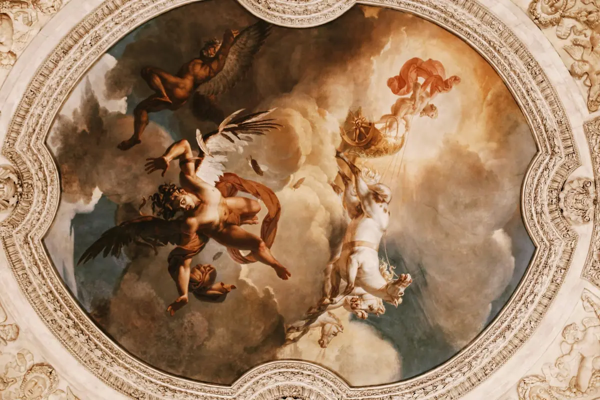 Une fresque au plafond représente des figures mythologiques, dont des humains ailés et des chars, sur fond de ciel nuageux spectaculaire.
