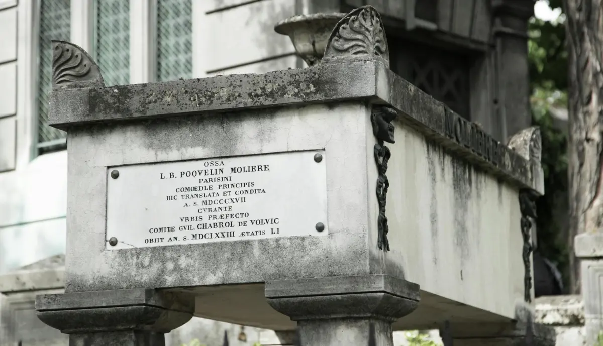 Extérieur d'un vieux tombeau en pierre avec une plaque, inscrite en latin, détaillant la vie et la mort de L.B. Poquelin Molière.