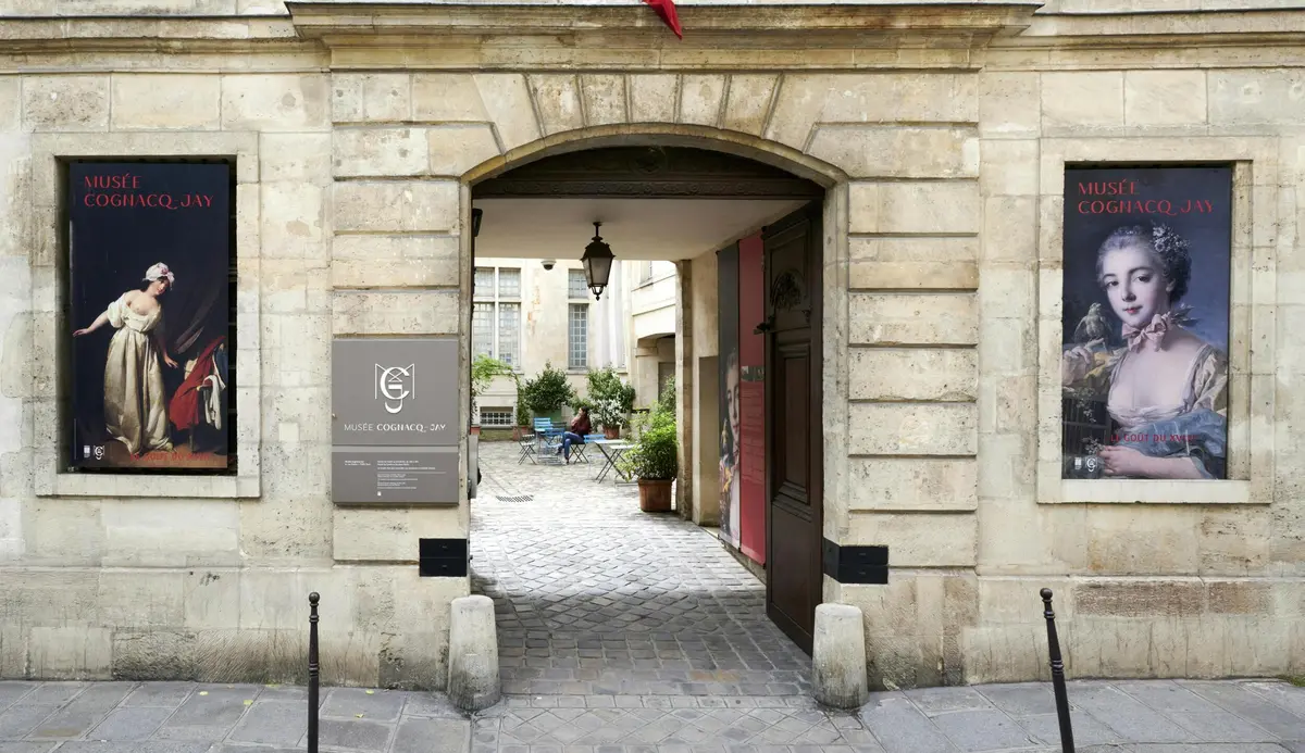 An entrance to the Musée Cognacq-Jay in Paris, featuring a poster of a woman in historic attire on the exterior wall.