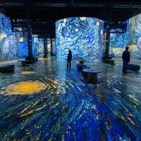 Des visiteurs se trouvent dans une exposition d'art immersive où « La Nuit étoilée » de Van Gogh est projetée sur les murs et le sol. &copy; Culturespaces___Cyrille_de_la_Motte_Rouge