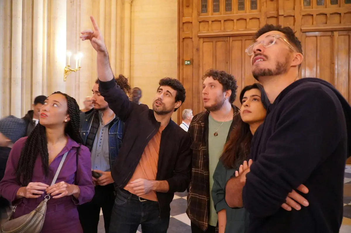 The supplier guides and points out details inside Notre Dame Cathedral.