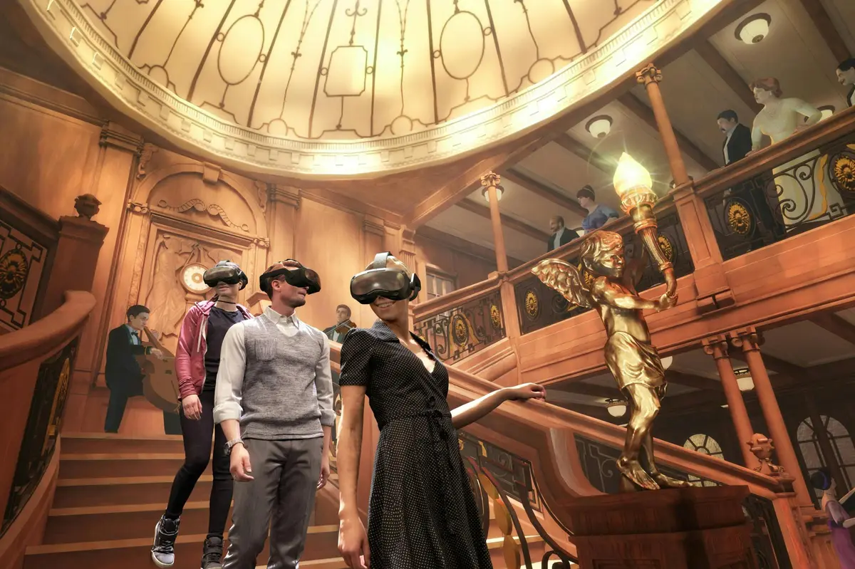 Des personnes portant des casques de RV dans une pièce ornée d'un grand escalier et d'un éclairage décoratif.