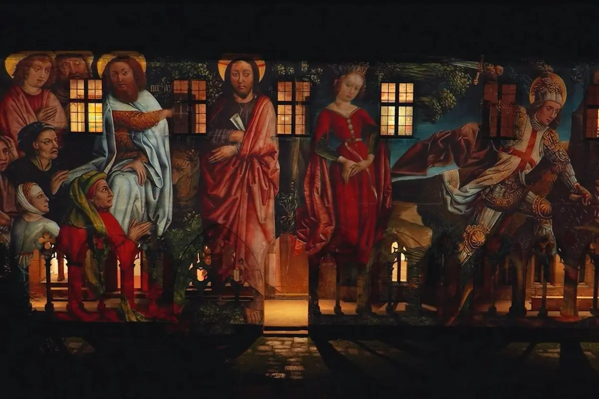 Projection d'une œuvre d'art de style Renaissance représentant des scènes bibliques sur la façade d'un bâtiment, la nuit.