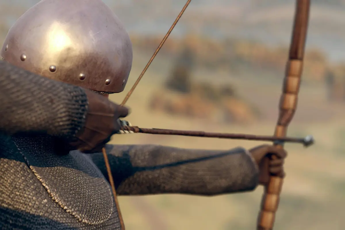 Un archer médiéval en cotte de mailles et coiffé d'un casque tire un arc et vise au loin.