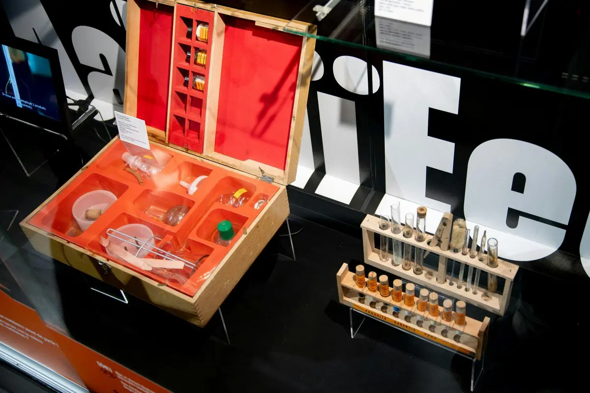 Vitrine avec un set de chimie vintage, comprenant des tubes à essai, des béchers et des bouteilles, sur un fond avec le texte LIFE.