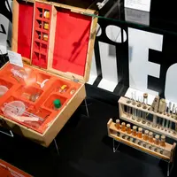 Vitrine avec un set de chimie vintage, comprenant des tubes à essai, des béchers et des bouteilles, sur un fond avec le texte LIFE. &copy; Villa de Colmar