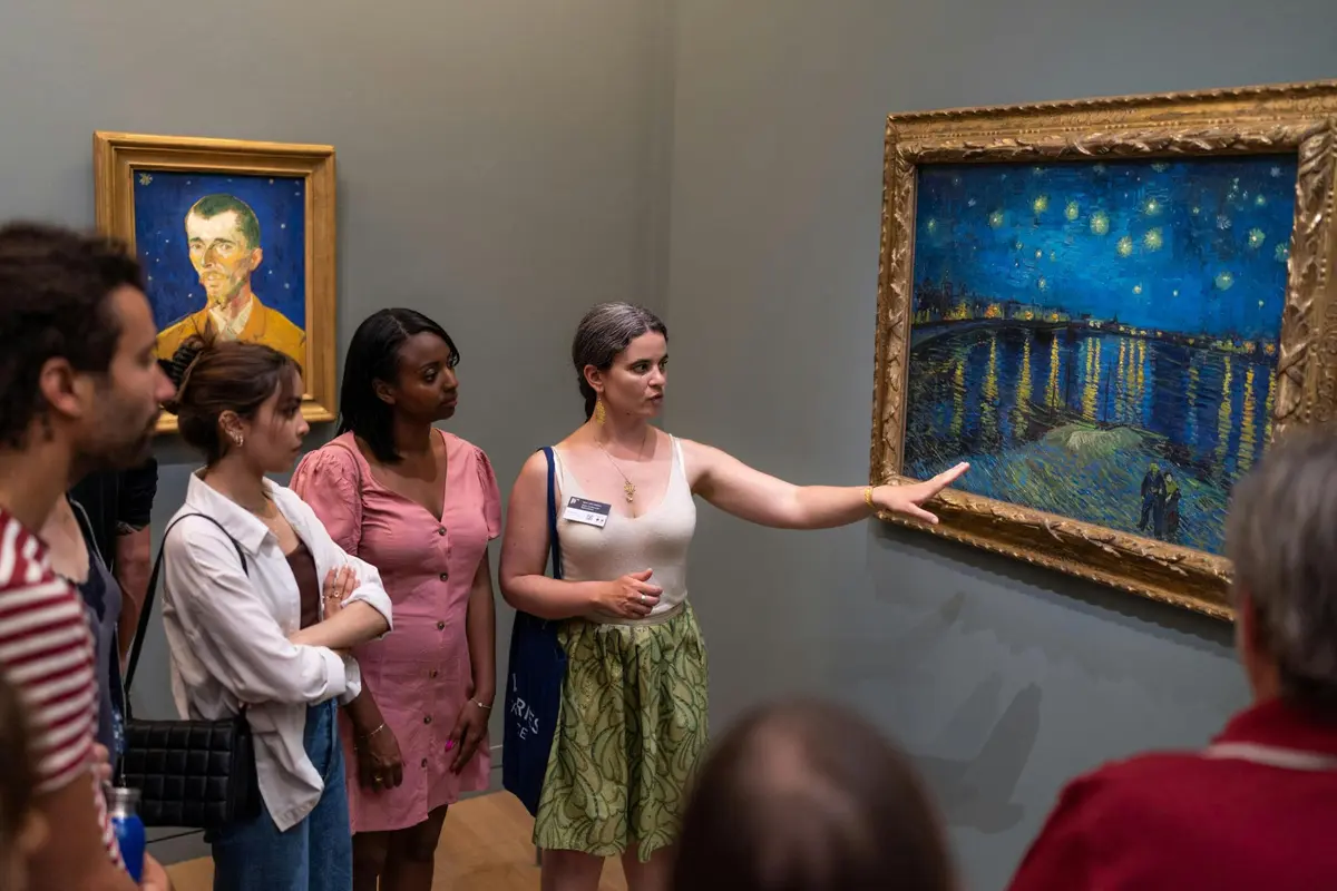 Guide explaining the painting Starry Night over the Rhone by Van Gogh