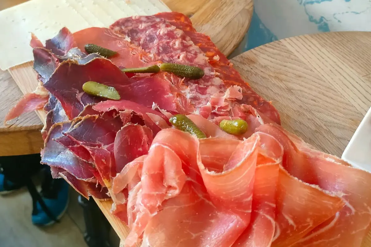 Tranches de jambon servies sur une planche avec des cornichons