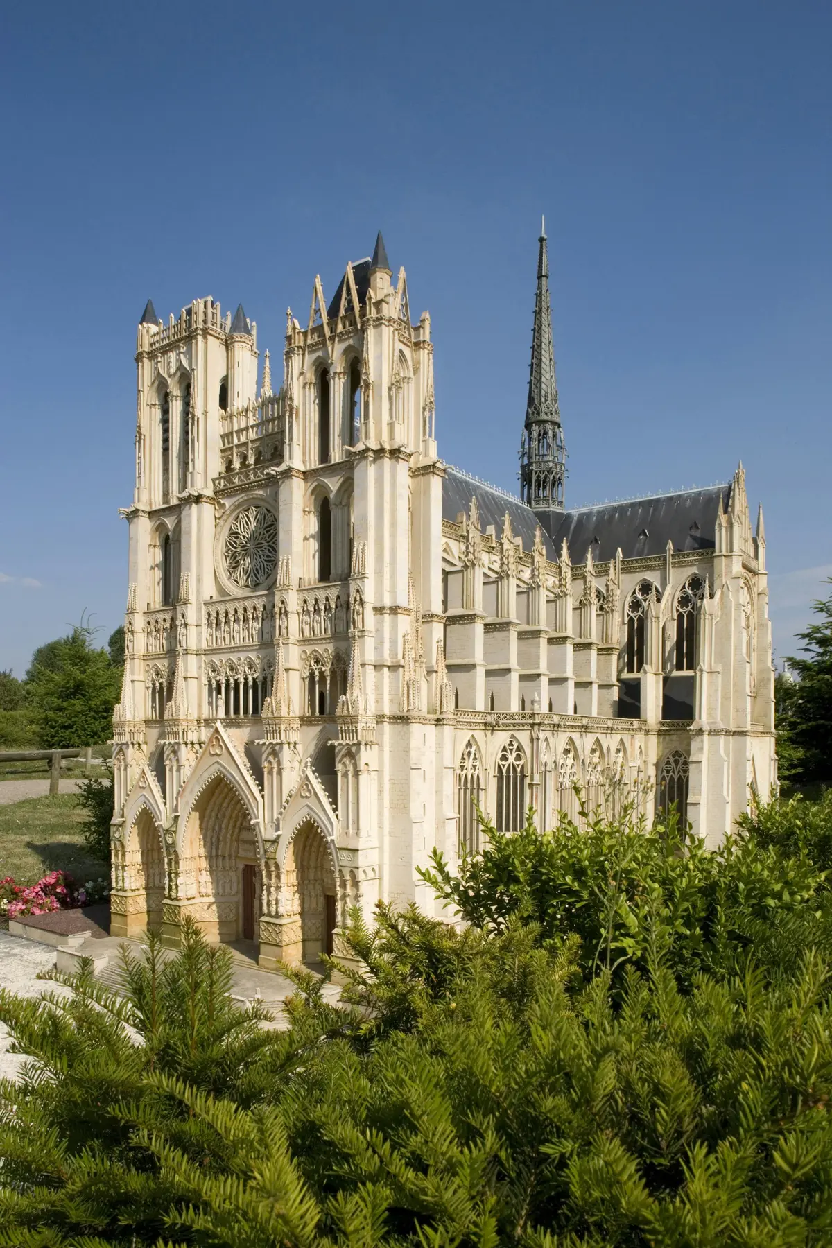 Modèle complexe d'une cathédrale gothique avec des arcs, des tours et des flèches détaillés, sur fond de ciel bleu clair.