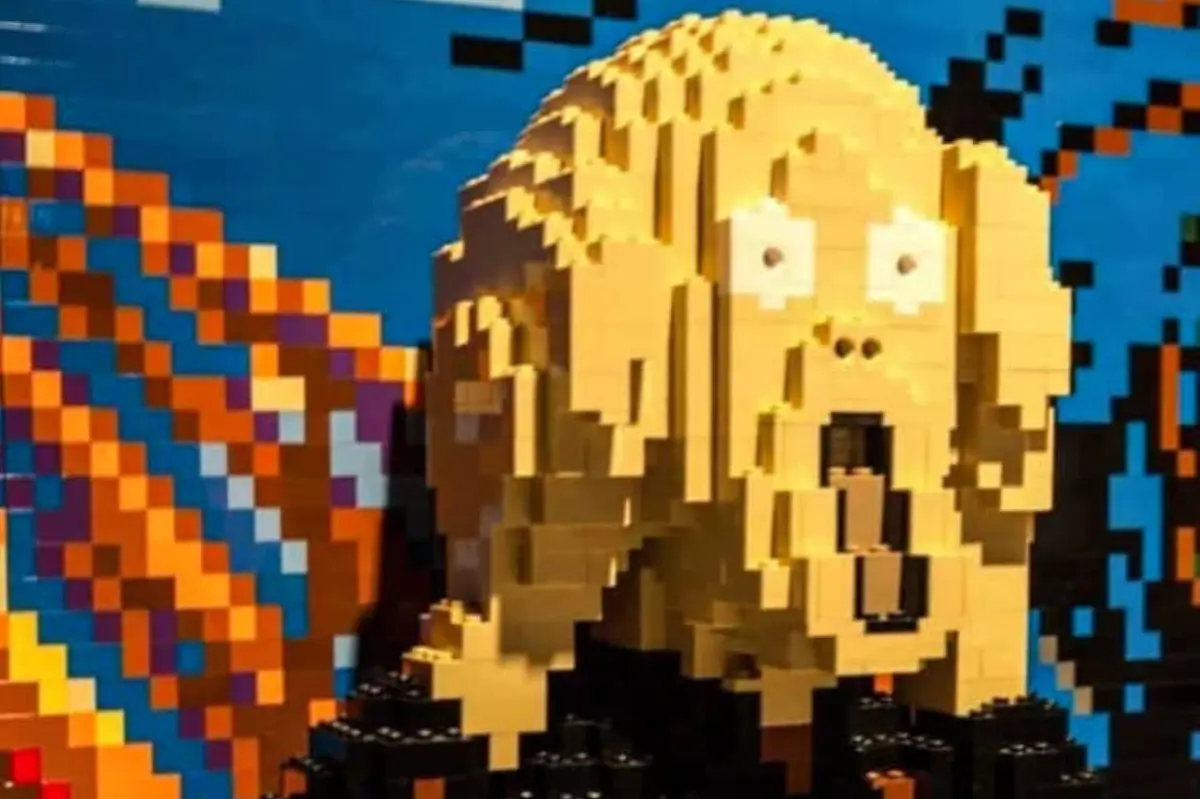 Une sculpture en Lego représentant le visage tiré du tableau « Le Cri » d'Edvard Munch, sur fond coloré.