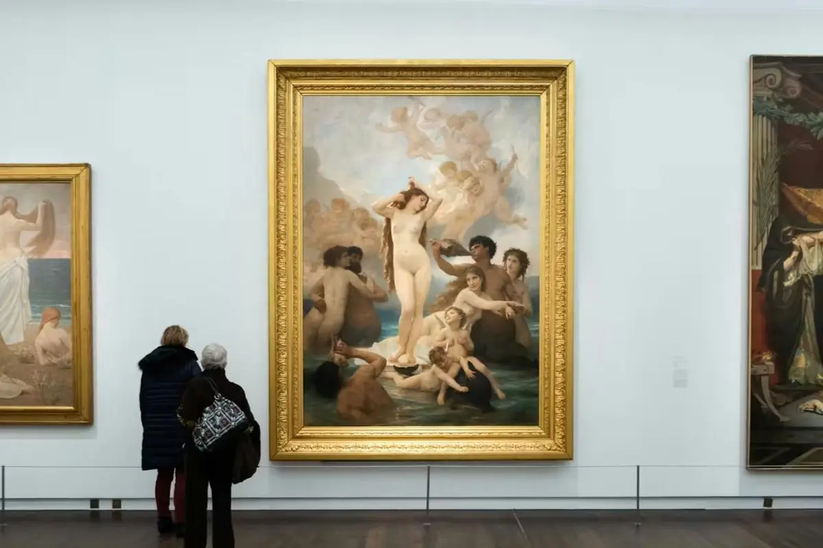 Un mur de musée sur lequel est accroché un grand tableau encadré représentant une scène classique mettant en scène un nu entouré d'autres personnages.