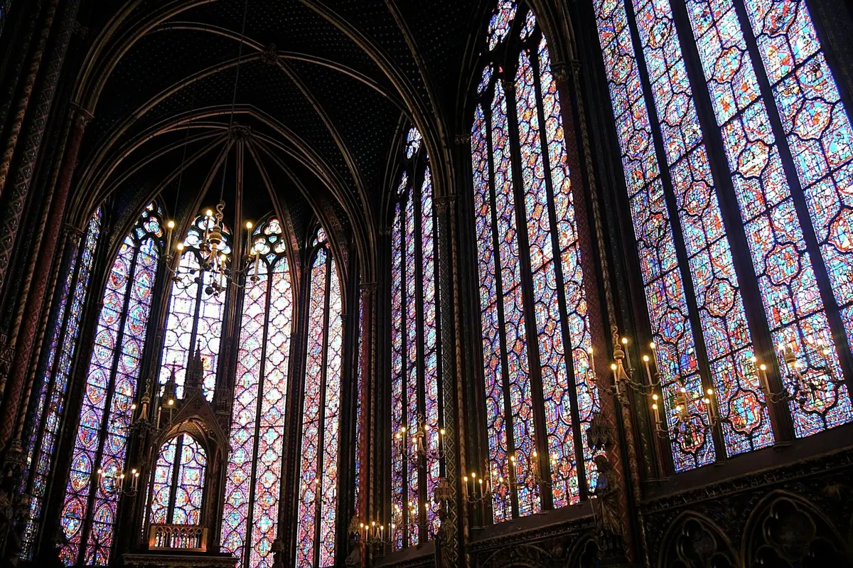 Intérieur de style gothique orné de hauts vitraux et de détails architecturaux complexes.