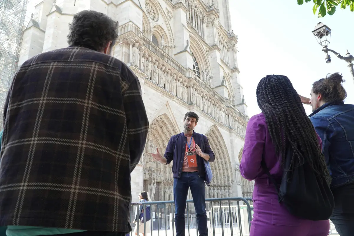 A guide in front of Notre Dame Cathedral talking to a small group of guests