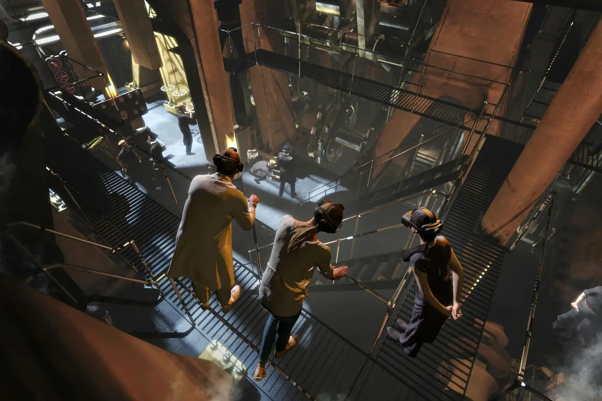 Trois personnes portant des casques de RV se tiennent sur une passerelle métallique surplombant un intérieur industriel à plusieurs niveaux.