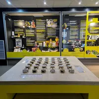 Exposition avec des panneaux de texte, des accents jaunes et des pièces de jeu interactives sur une table, le tout à l'intérieur d'une salle d'exposition. &copy; Villa de Colmar