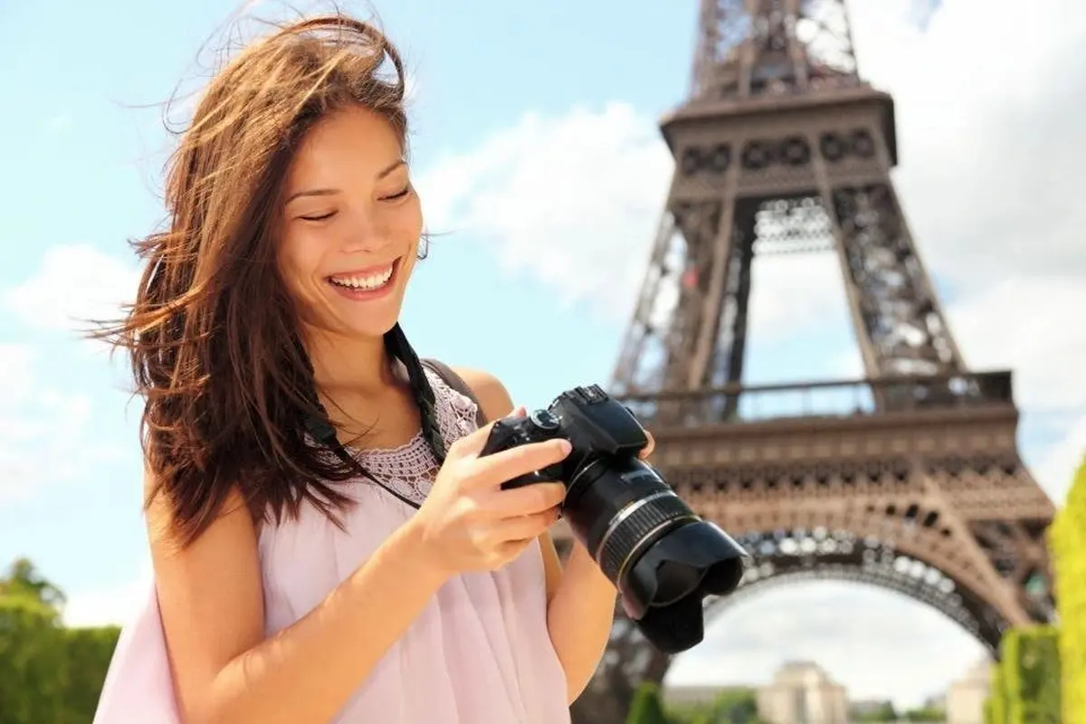A woman taking picture of the Eiffel Tower