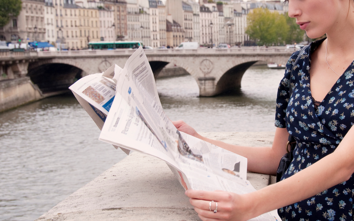 Personne lisant le journal au bord de la Seine.