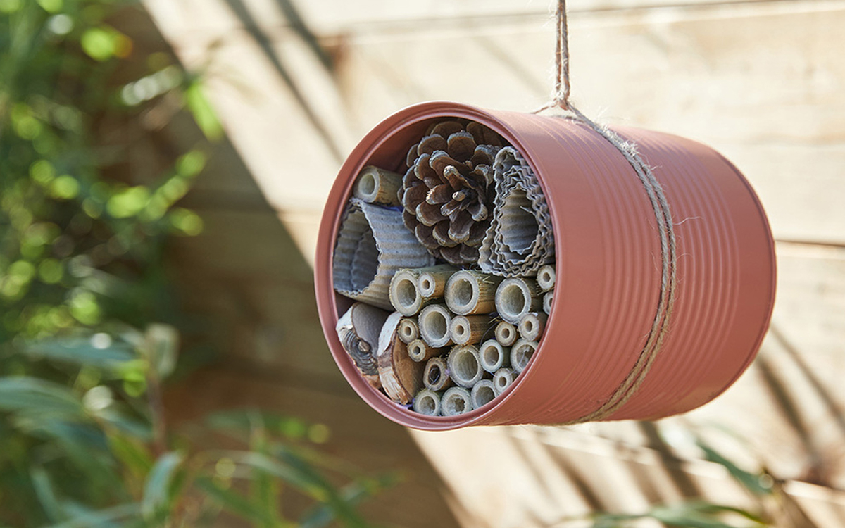 photo d'un hôtel à insectes fabriqué avec du bambou et une boîte de conserve