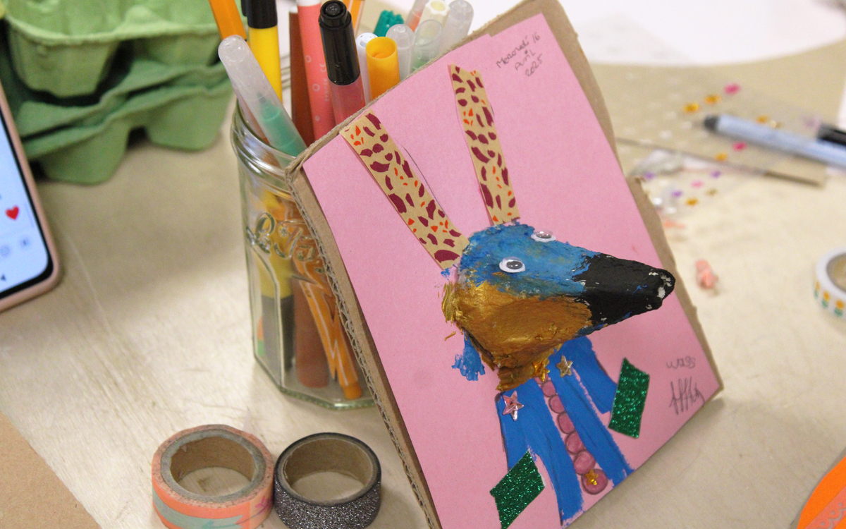 Photographie d’un portrait de lapin réalisé par un enfant lors de l’atelier, avec des papiers découpés, des feutres et des crayons de couleur etc.