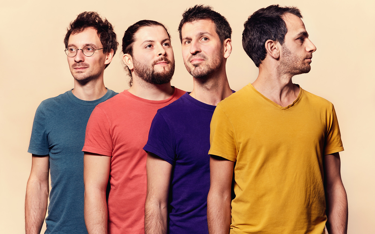 Groupe Bazar, quatre musiciens en portrait studio coloré, regardant ensemble vers la droite