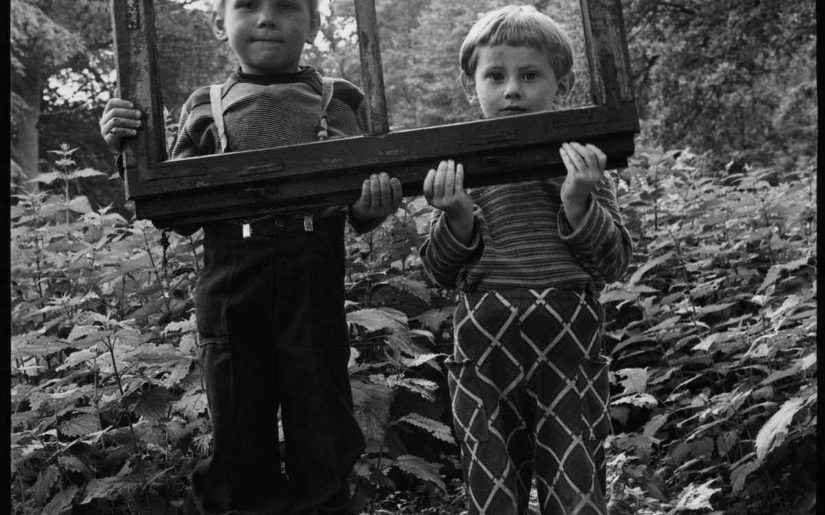 Bogdan Konopka. 2 enfants tenant le vantail d'une fenêtre en guise de cadre à Kliczkow