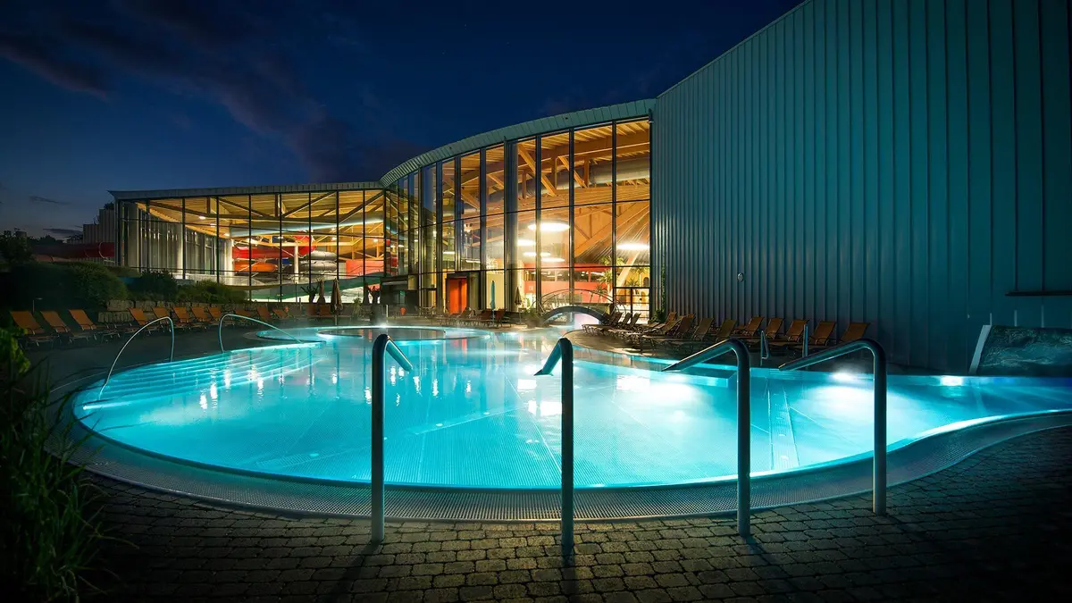 Les piscines extérieures d'aquabasilea illuminées en soirée
