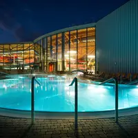 Les piscines extérieures d'aquabasilea illuminées en soirée DR