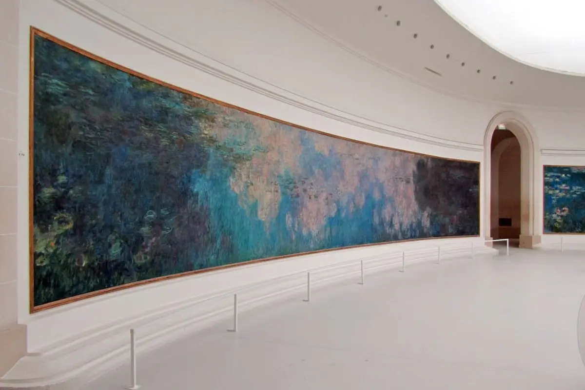 Une grande peinture panoramique aux tons bleus et verts abstraits, exposée dans une galerie spacieuse aux murs blancs.