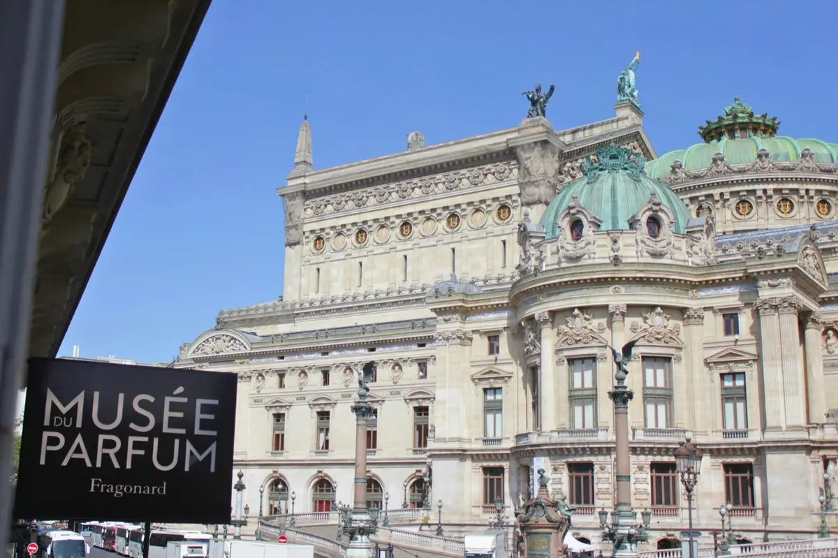 Un bâtiment historique aux détails architecturaux raffinés, surmonté d'un dôme vert sous un ciel bleu limpide. Une pancarte porte l'inscription « MUSÉE ».
