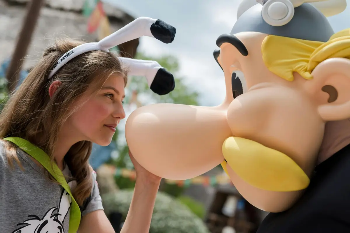 Une femme portant des oreilles de lapin regarde un objet gonflable caricatural en plein air.