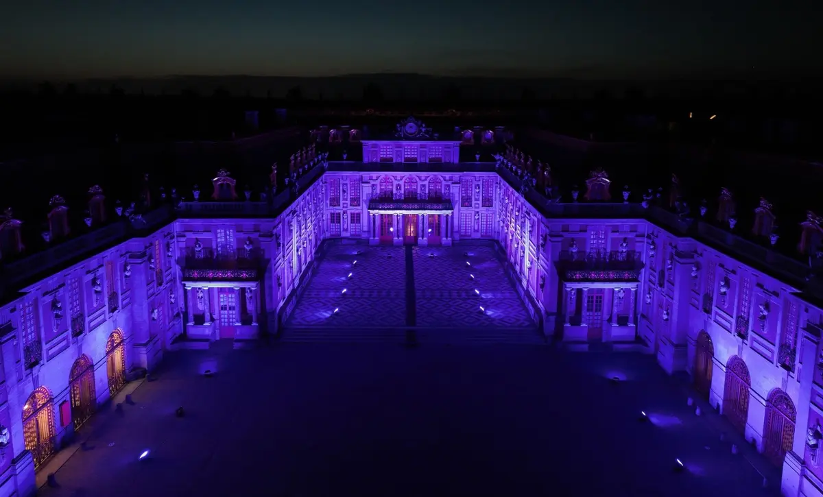L’éclairage violet transforme les façades du Château de Versailles