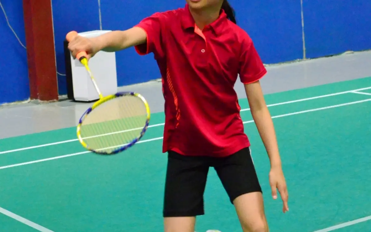 Enfant en plein entraînement lors d'une séance de badminton.