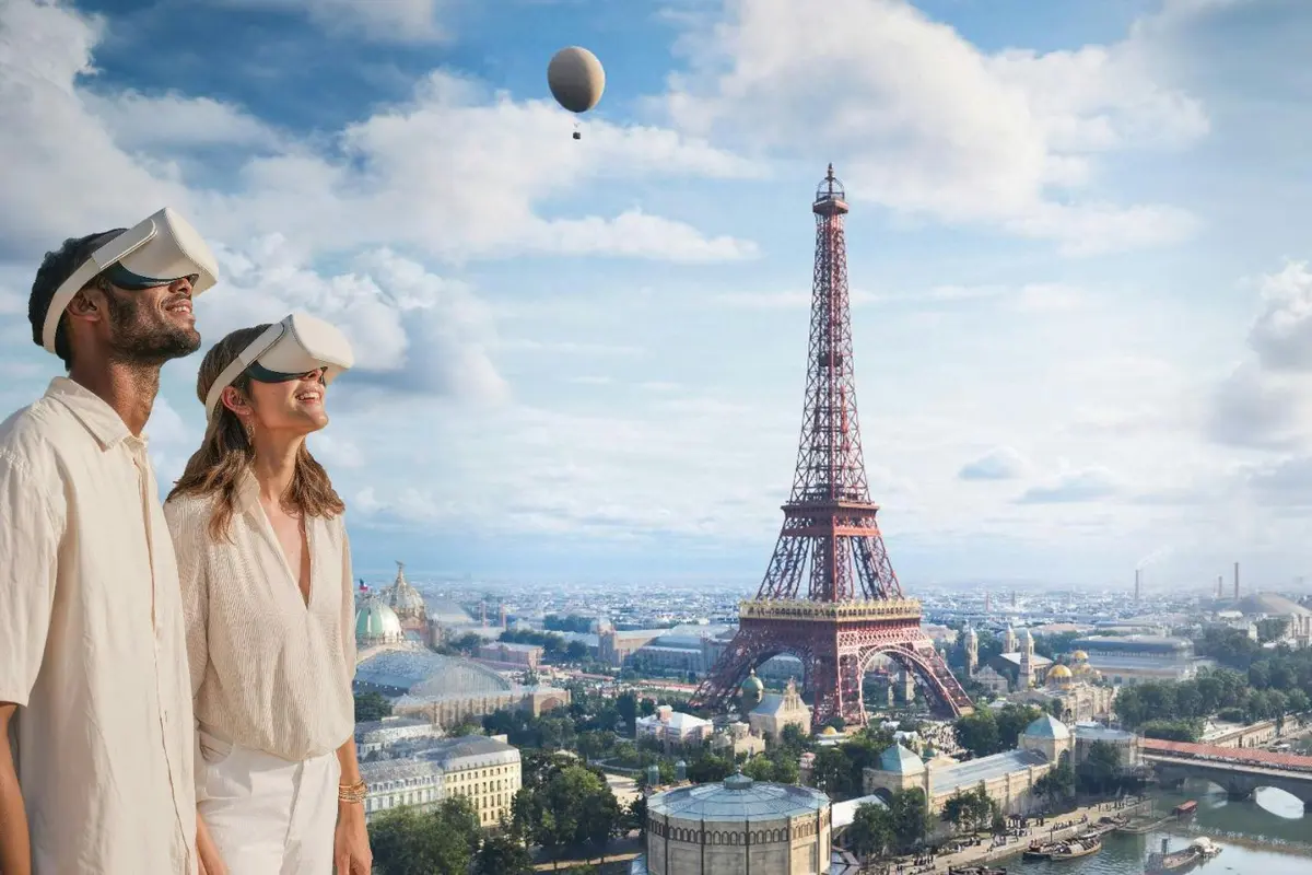 Deux personnes portant des casques de réalité virtuelle se tiennent devant un décor représentant la Tour Eiffel et une montgolfière.