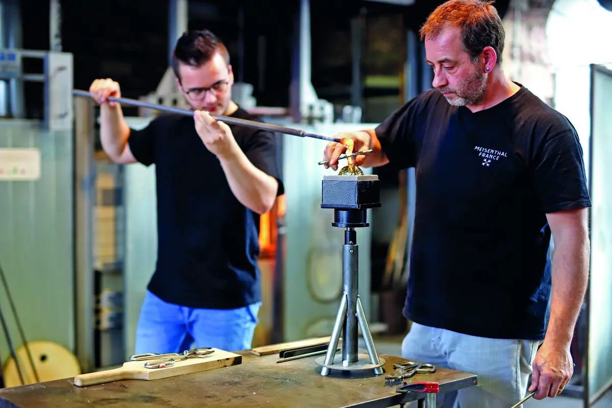 Jean-Marc Schilt et son collègue verrier travaillent sur la boule de Noël 2021