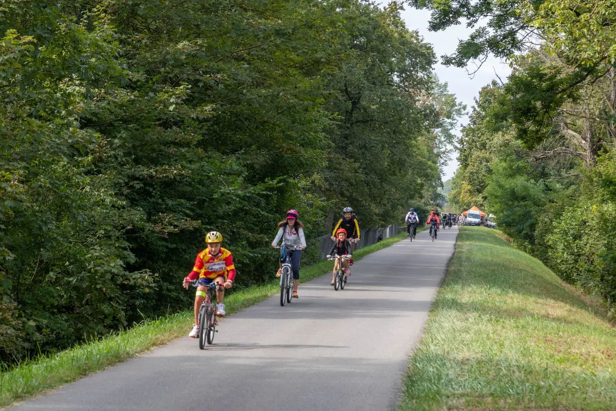 Des familles et groupes d’amis pédalent le long d’une piste cyclable
